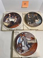 Three Norman Rockwell collector plates displayed on their original boxes, showing detailed Americana scenes including children and adults at home, dining, and working.