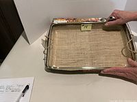 Rectangular clear glass Pyrex baking dish, approx 9x15, shown on a white background, with hands holding it by the sides to show scale.