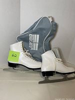 White Bauer women's figure skates size 10 shown with light blue Bauer skate bag against white background.