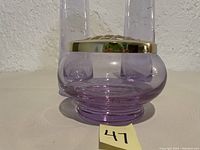 Close-up of the lavender glass flower vase base with silver flower frog top showing translucent lavender color and metal lid.