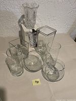 Front view of all 7 vases showing different shapes and sizes with lead crystal vase at back on box.