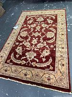 Full view of rectangular rug laid flat showing overall color, pattern and fringe