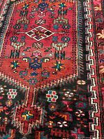 Center section showing elongated hexagonal medallion on red ground with blue, green, yellow and white motifs