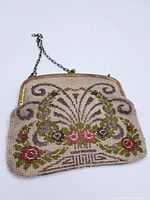 Front view of the antique beaded purse displaying floral beadwork and metal frame with chain handle.