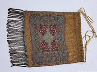 Front view of the antique beaded purse showing the floral pattern and fringed tassels