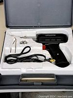 Complete kit in hard plastic carrying case with soldering iron gun, metal stand, and coil of solder wire