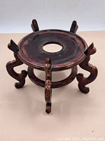 Full view of the Chinese wooden jardiniere vase stand, showing circular top with central hole and four curved legs.