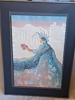 Full view of the framed embossed print showing a woman with long blue hair and crown, holding flowers with a pastel colored background and embossed details.