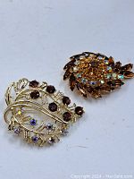 Pair of vintage rhinestone brooches photographed on a white background.