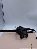 Full view of the Poulan electric chainsaw showing overall body and chain bar with chain.