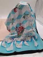 Silk scarf showing floral and geometric cube pattern with Tiffany & Co. logo, highlighting its colors and overall design layout.