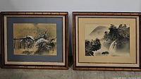 Shows two framed black and white Asian art prints side by side with bamboo style frames against a concrete floor.
