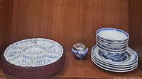 Photo showing blue and white porcelain plates, bowls, and Mexican pottery jar with pewter lid.
