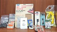 Photo showing variety of items including sanding sheets, wire connectors, light switch covers, felt pads, and other repair components.