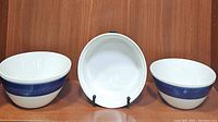 Set of 3 serving bowls displayed side by side on shelf showing blue decorative band