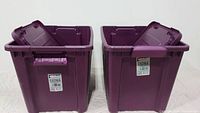 Two purple plastic storage totes with lids open and visible thick walls and handles.