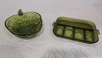 View of two green glass bowls: one grape-shaped and one rectangular divided fruit bowl with three compartments.