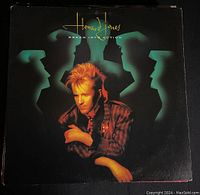Cover of Howard Jones album "Dream Into Action" showing the artist's photo with stylized shadows in the background.