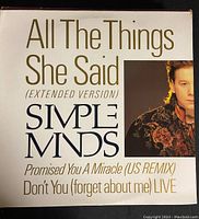 Front cover of Simple Minds vinyl single titled "All The Things She Said" Extended Version with additional track information and a partial band member photo.