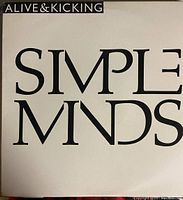 Vinyl album cover for 'Alive & Kicking' by Simple Minds featuring black and white minimalist large font text on white background.