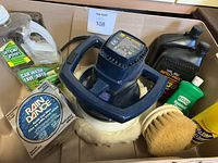 Photo of car polish, tools, brushes and cleaning liquids packed in box.