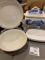 Photo showing the electric soup tureen with lid featuring a blue scenic design along with a large white bowl and a rectangular white platter with silver decorative trim.
