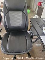 Front view of black ergonomic computer chair showing padded seat and backrest with diamond quilted pattern.