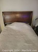 Photo shows a brown wooden kid's bed frame with a solid rectangular headboard. The mattress is not included.