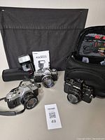 All three cameras, flash, manual and black padded case