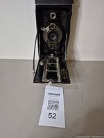 Front view of the camera with folding bellows extended showing lens and shutter plate.