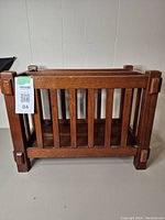 Front-facing photo showing the wooden magazine rack with vertical slats and square corner posts, highlighting structure and wood finish.