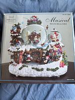 Box image showing vendor packaging with illustration of the Christmas musical waterglobes set.