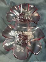 Top view of a pink frosted glass double bowl candy dish with ruffled edges and floral berry pattern in the center