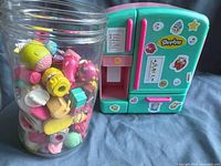 Shopkins fridge playset with closed doors and jar of assorted Shopkins figures beside it