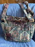 Front view of Tilley Endurables handbag showing intricate multicolored geometric pattern and wooden handles.