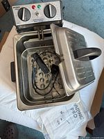 Waring Pro professional grade deep fryer showing open lid, frying basket inside, attached power cord, and control panel with temperature and timer dials.