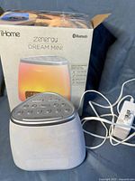 Photo of iHome Zenergy Dream Mini sleep therapy machine with original box and power adapter showing device front and side.