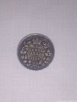 Reverse of 1906 Canadian 5 cent coin with crowned numeral and maple leaf wreath.