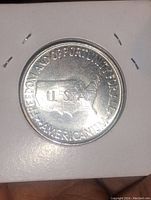 Reverse of 1952 silver USA half dollar coin showing map of the USA and inscription about freedom and opportunity, with clear details.