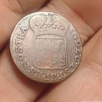 Obverse side of antique copper coin showing crown and detailed shield crest with partial lettering around edge.