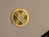Top side of the antique Chinese coin showing clear Chinese characters and square hole.
