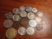Photo of 20 Canadian and world silver and other metal coins showing obverse and reverse sides with various designs including beaver, George VI, caribou and classical figure.