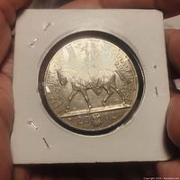 Reverse of coin showing Queen Elizabeth II riding a horse, inscribed with text and date 2002 along bottom.