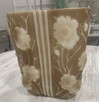 Front-side view showing beige milk glass vase with raised white Cosmos flowers and vertical stripes.