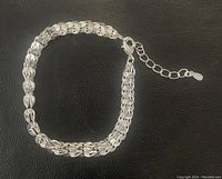 Full bracelet laid flat showing the Phoenix Tail design and adjustable extension chain