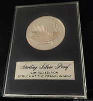Front side of the sterling silver proof coin showing olive branch and Hebrew inscription in acrylic case with label