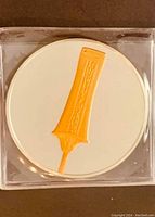 Close-up of coin showing gold highlighted Royal Scepter in clear plastic sleeve.