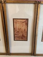 Full view of one framed print showing the gold frame with decorative corner accents and the central sepia da Vinci sketch.