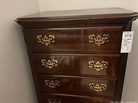 Front view showing top three drawers and brass handles