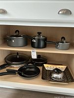 Pots and pans including three saucepans with lids and three frying pans shelf storage
